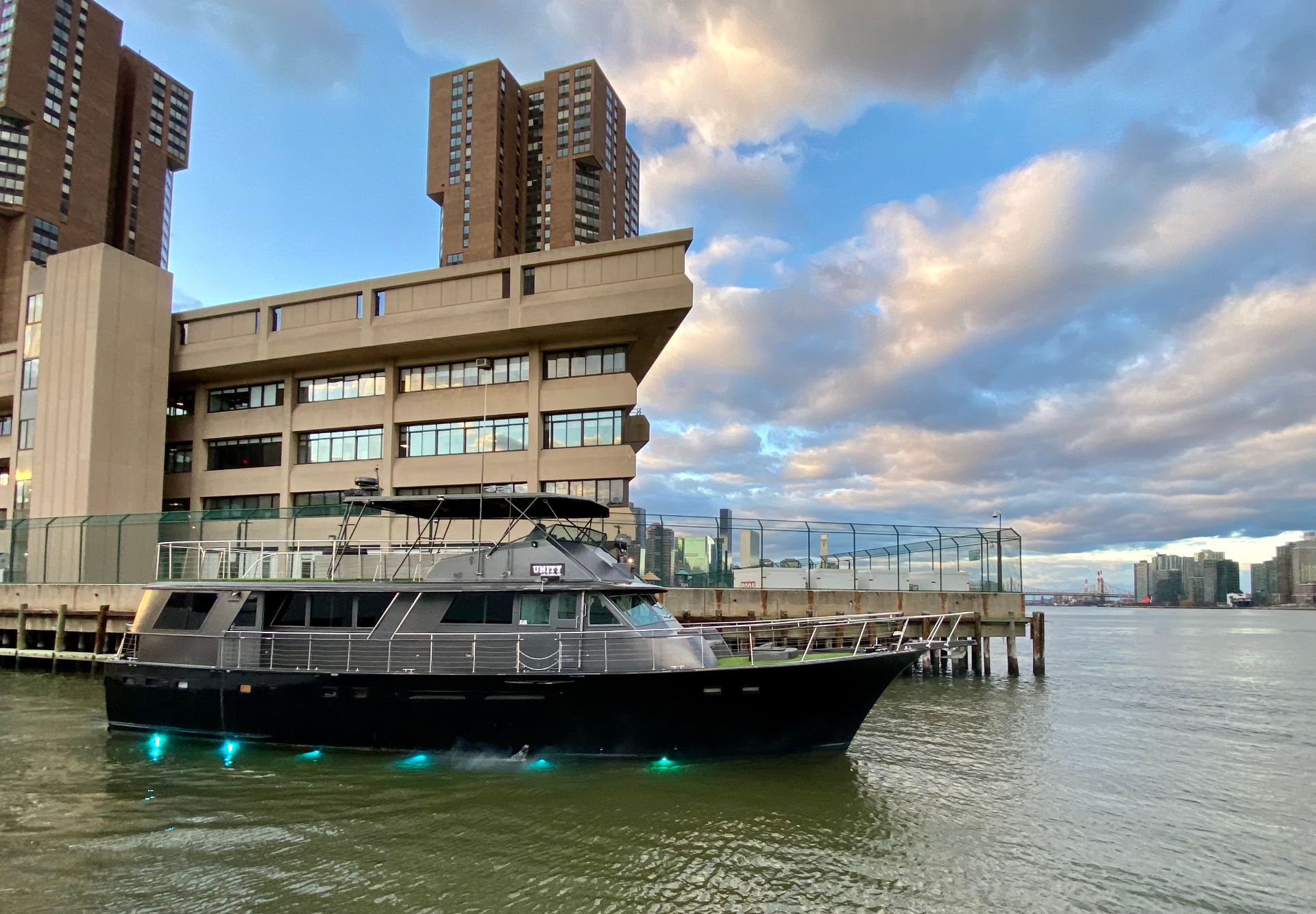 Unity yacht docked at Manhattan pier at golden hour